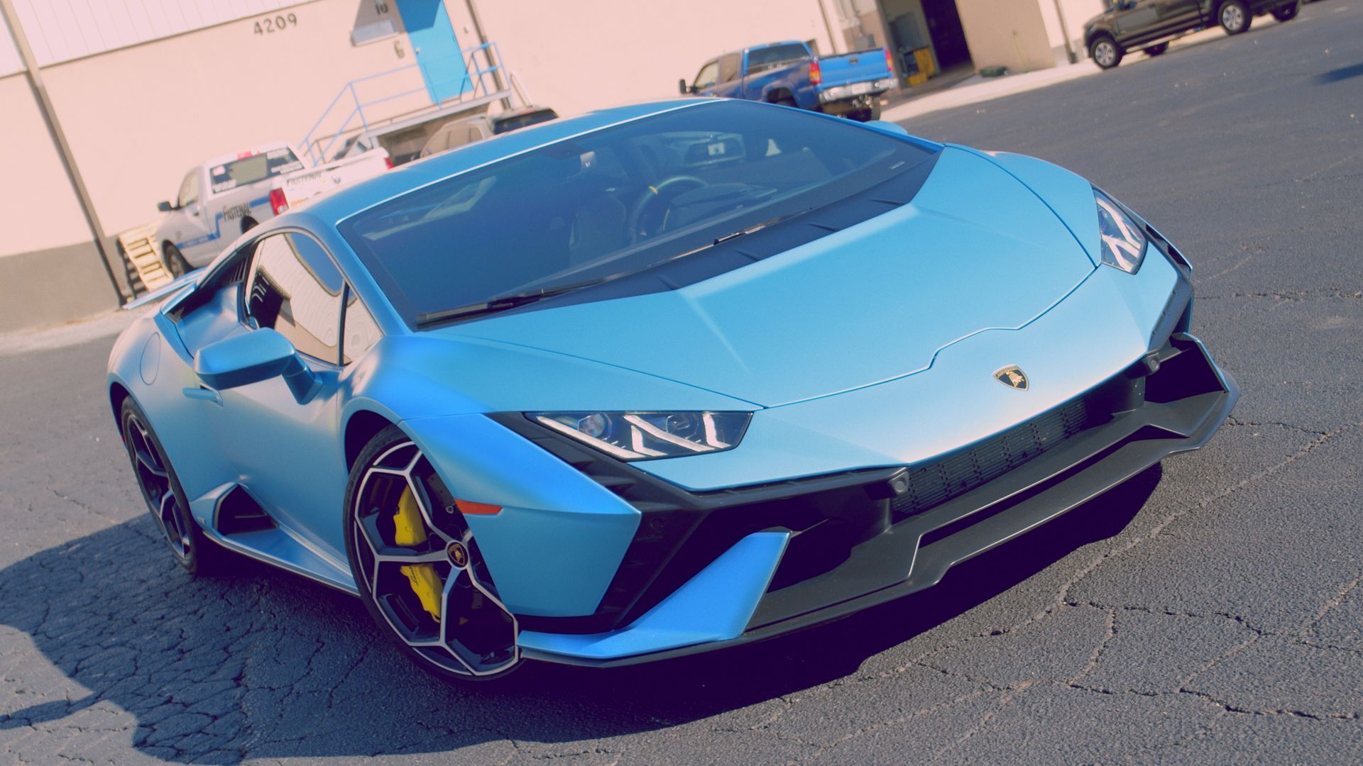 Blue Lamborghini sports car parked on a street.