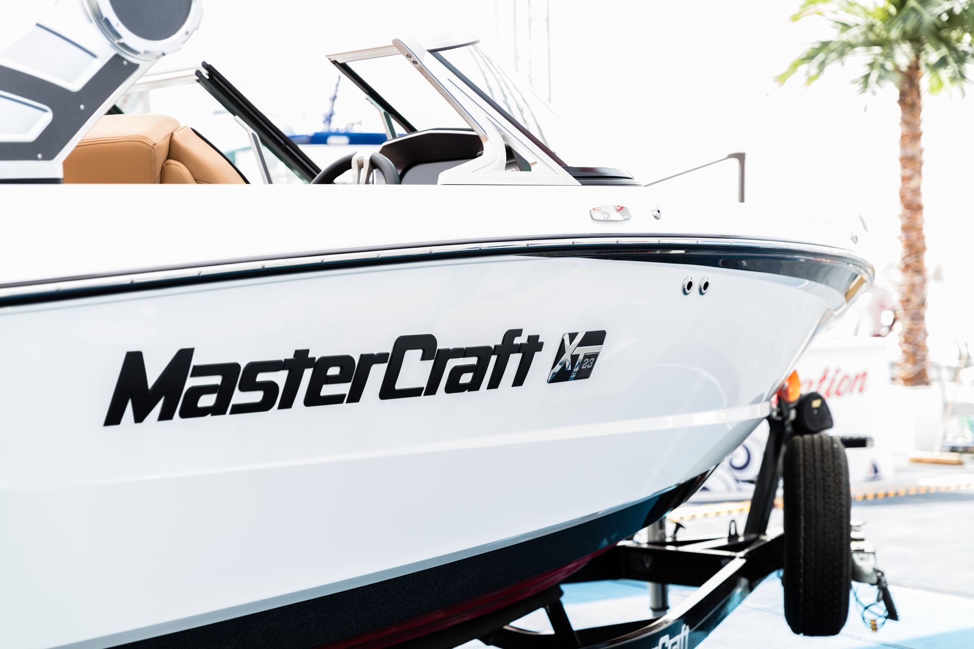 White MasterCraft boat with black lettering, parked on a trailer.