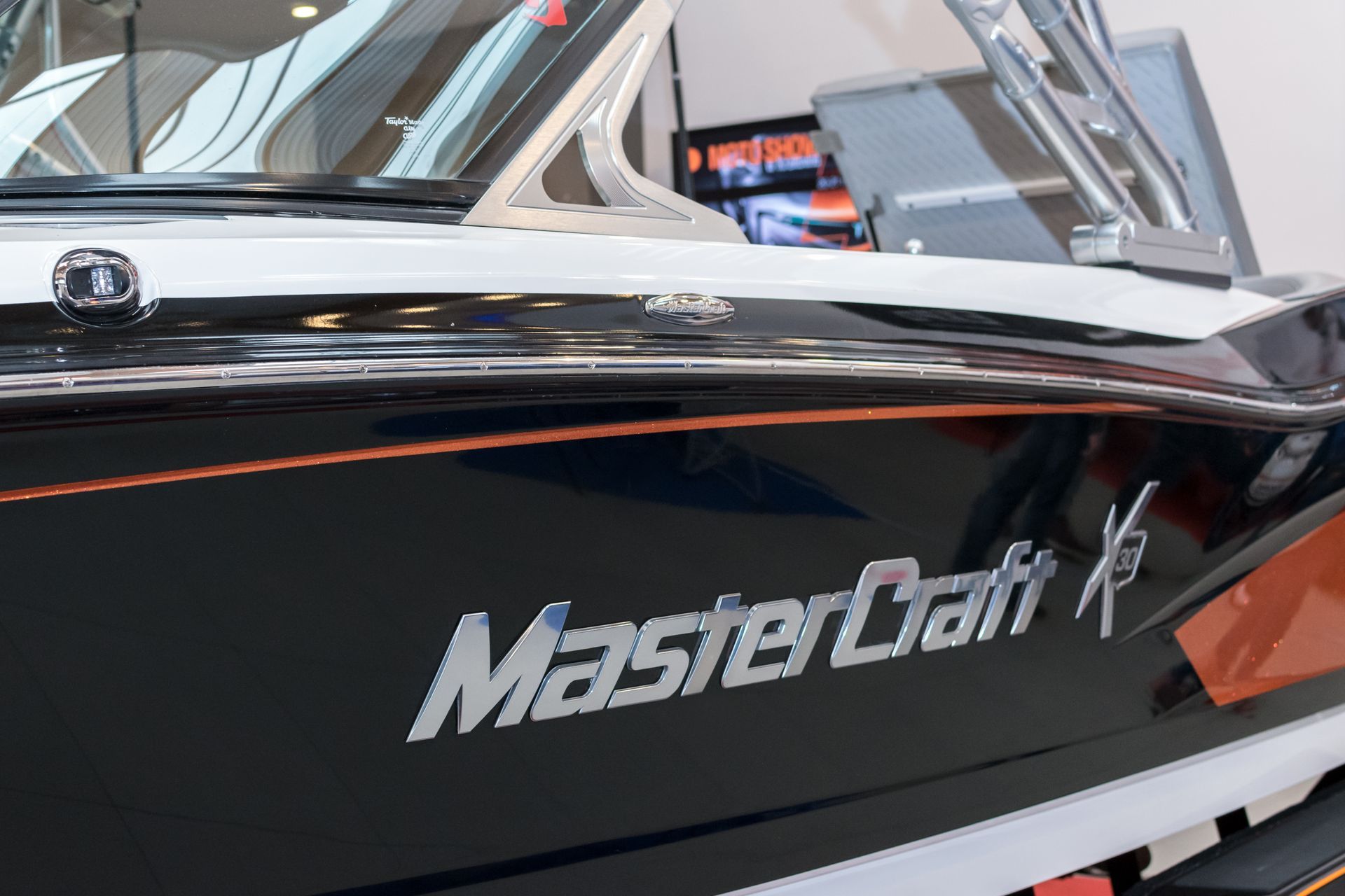 MasterCraft K boat with chrome lettering on black hull, orange accent line.