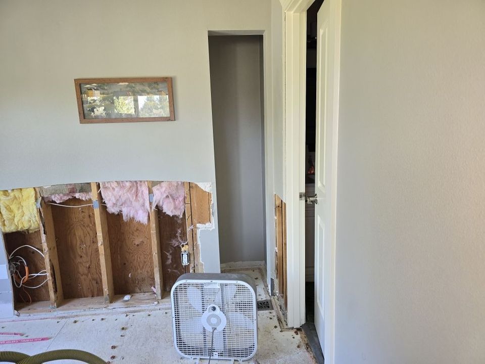 A ladder is sitting in front of a house under construction.