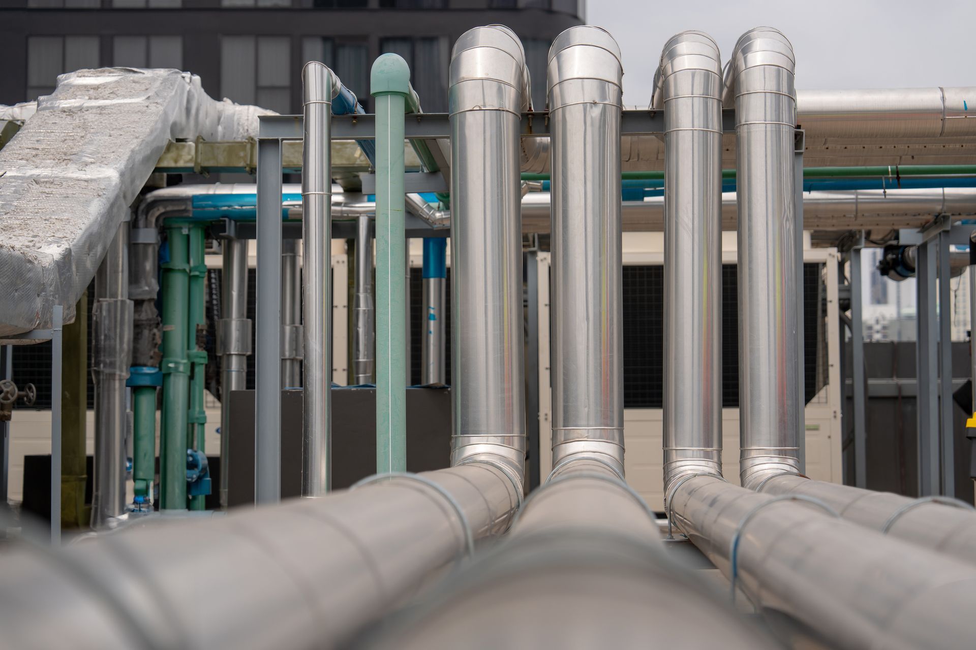 A row of stainless steel pipes are lined up in a factory.