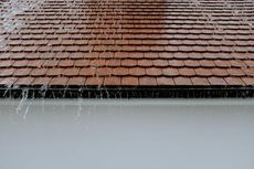 The rain is falling on the roof of a house.