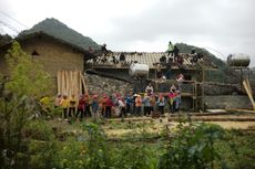 A group of people are standing in front of a building under construction.