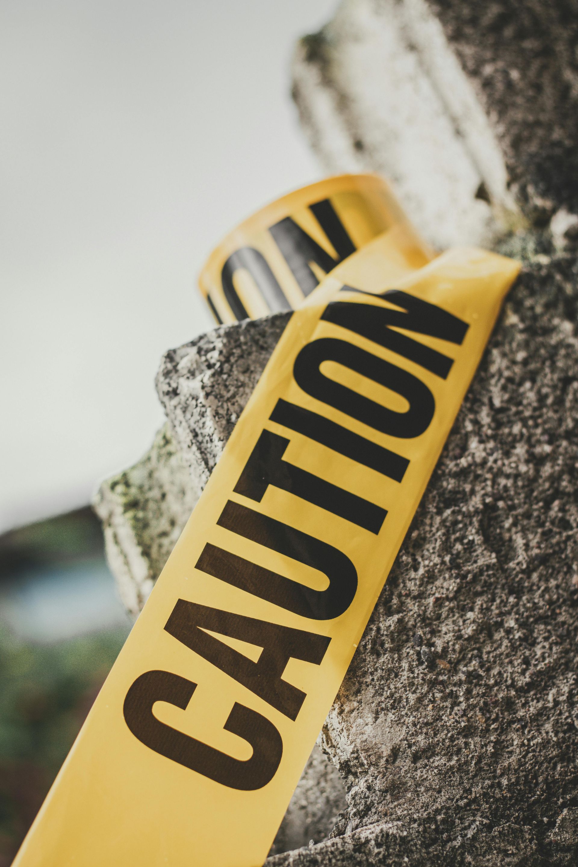 A close up of a yellow caution tape on a rock