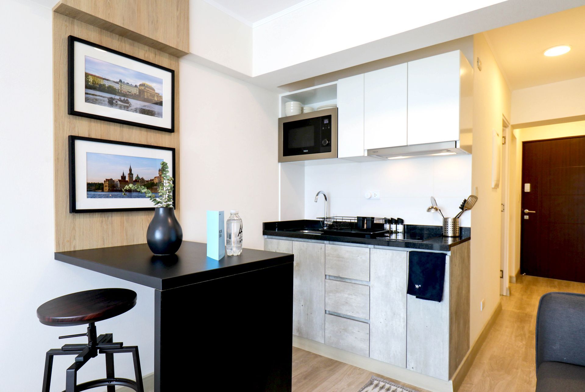 Un patio con mesa y sillas bajo una pérgola.