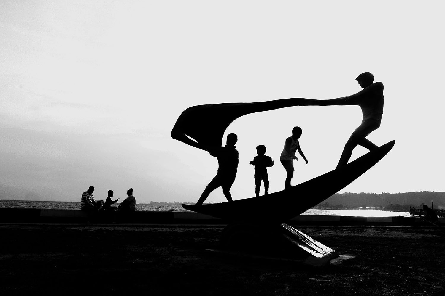 Una fotografía en blanco y negro de un grupo de personas en una playa.