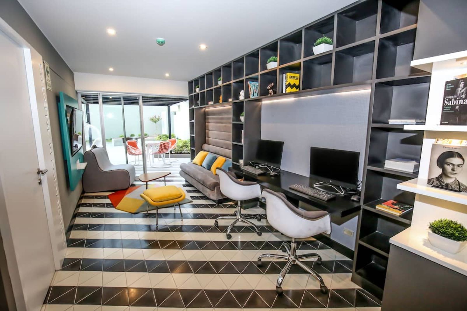 Una sala de estar con piso rayado y un escritorio para computadora.