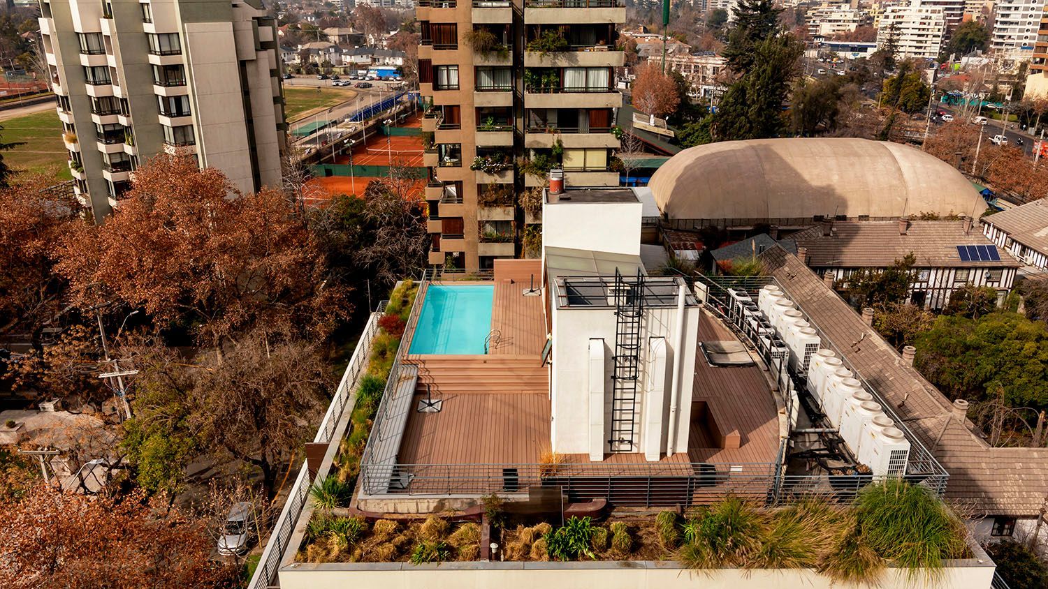 Vista aérea de un edificio con piscina en la azotea.