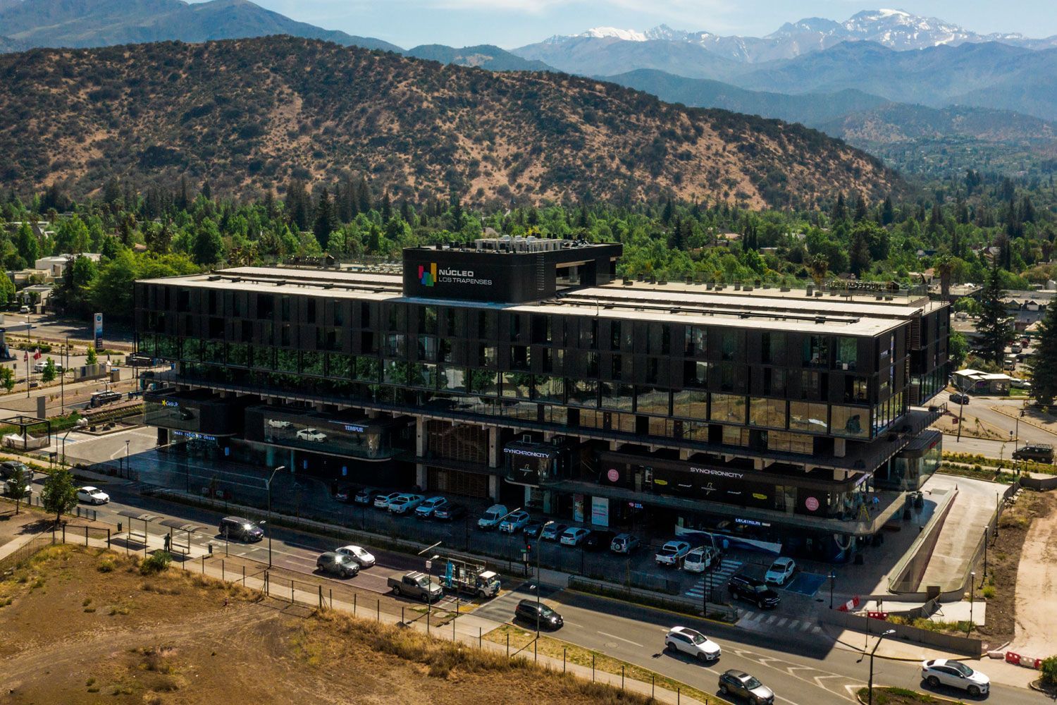 Una vista aérea de un gran edificio con montañas al fondo.