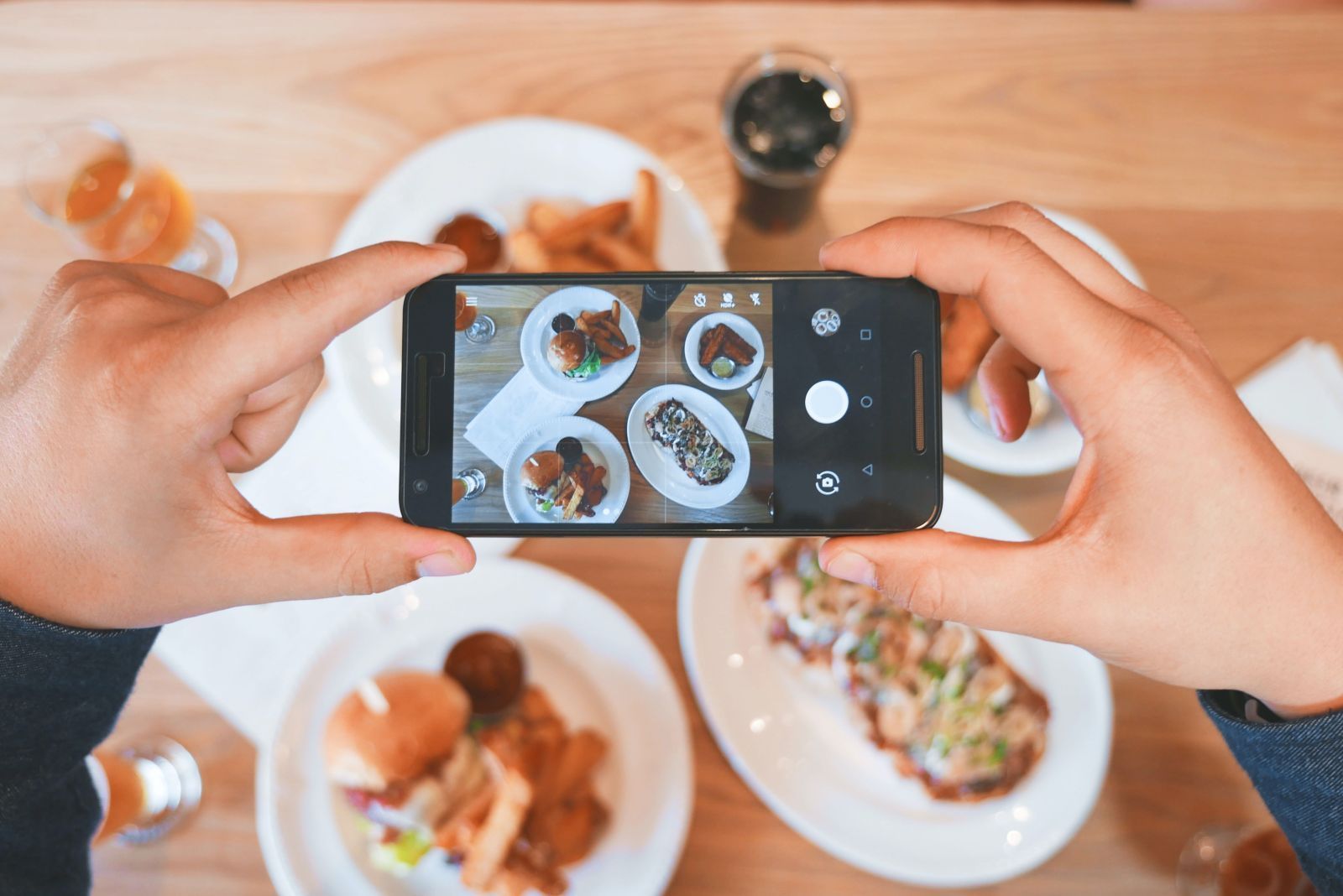 Una persona está tomando una fotografía de comida con un teléfono celular.