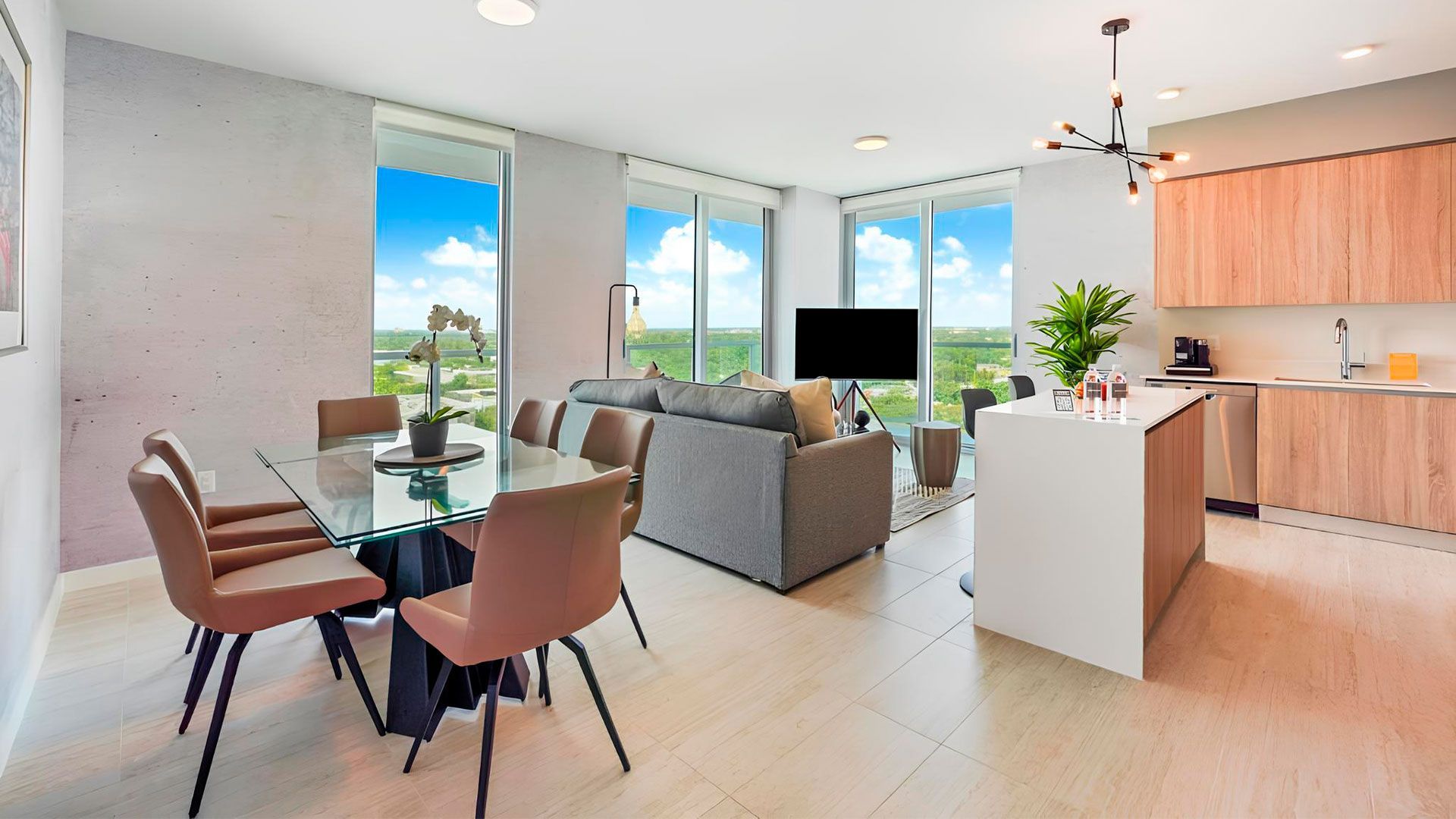 Alojamiento en Miami, un salón con mesa y sillas de comedor, un sofá y una televisión.