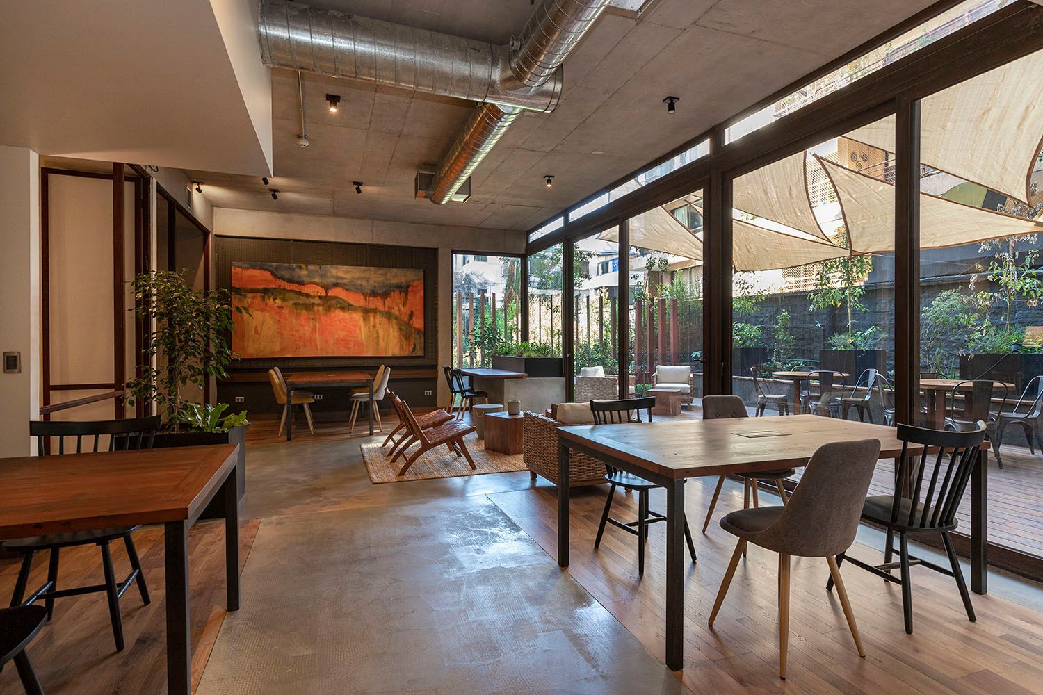 Nueva las Condes.Un salón grande con mesas y sillas y un cuadro en la pared.