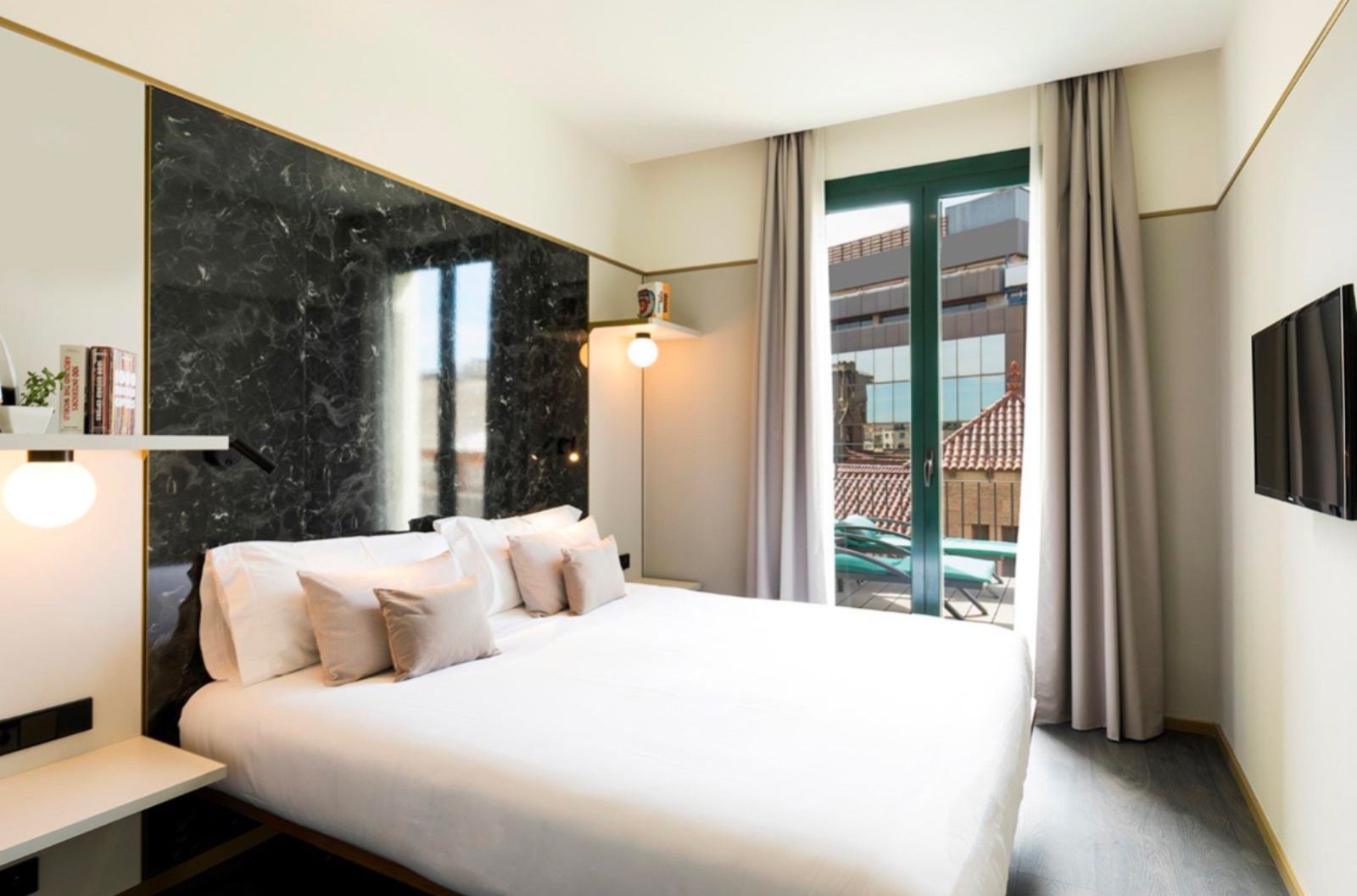 Una habitación de hotel con una cama grande y un balcón.
