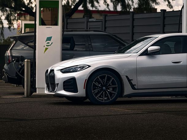 A white car is being charged at a charging station.