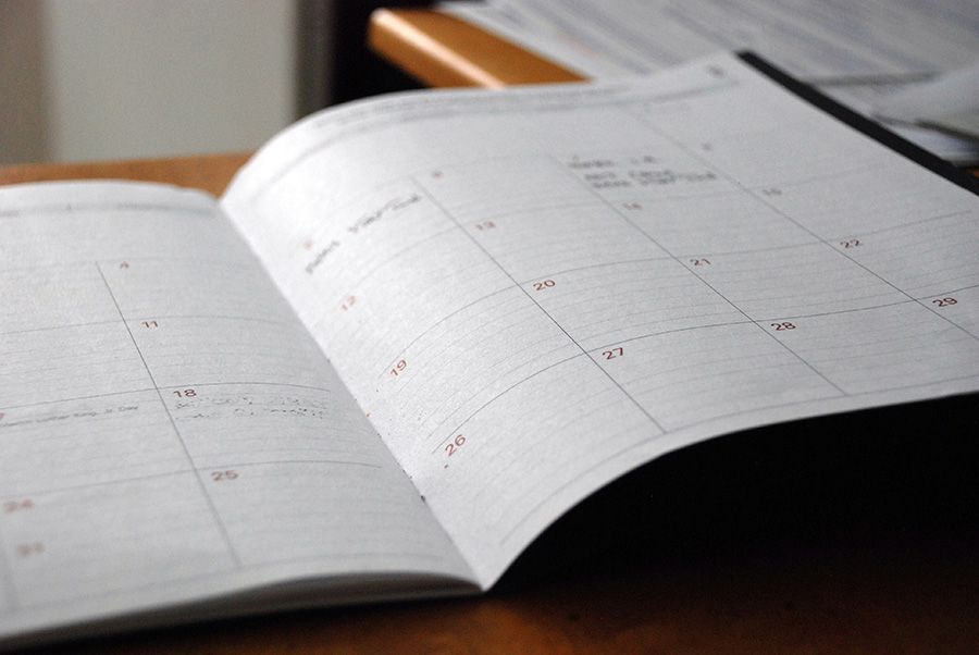 An open calendar is sitting on a wooden table.