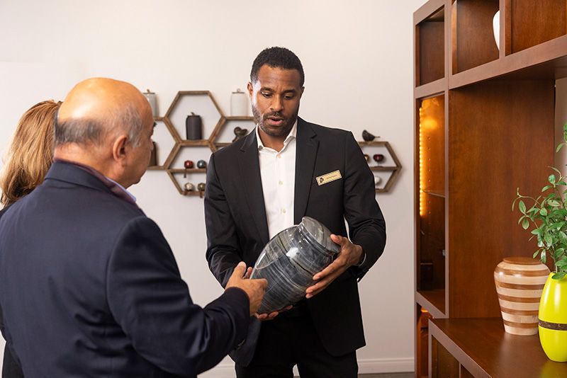 Staff Member working with couple looking at Cremation Urn