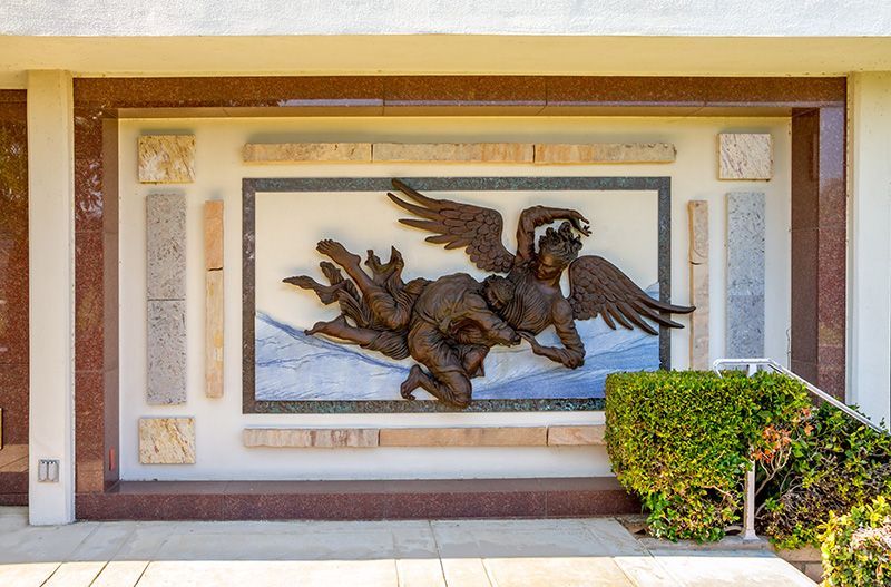 Bronze sculpture of Jacob wrestling Angel on wall by Mary Ann DeVine at Hillside