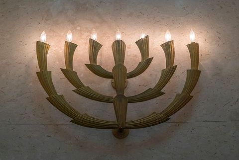 A menorah with candles lit up on a wall