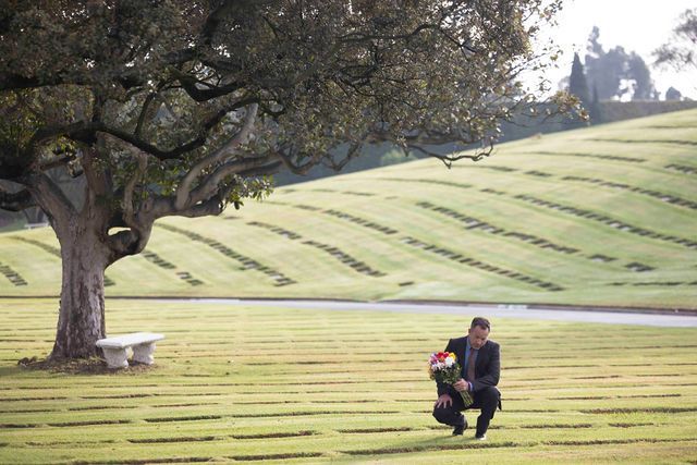 Cemetery grounds with person carrying bouquet of flowers