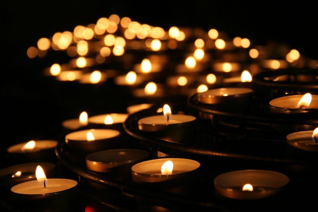 A bunch of lit candles in a dark room