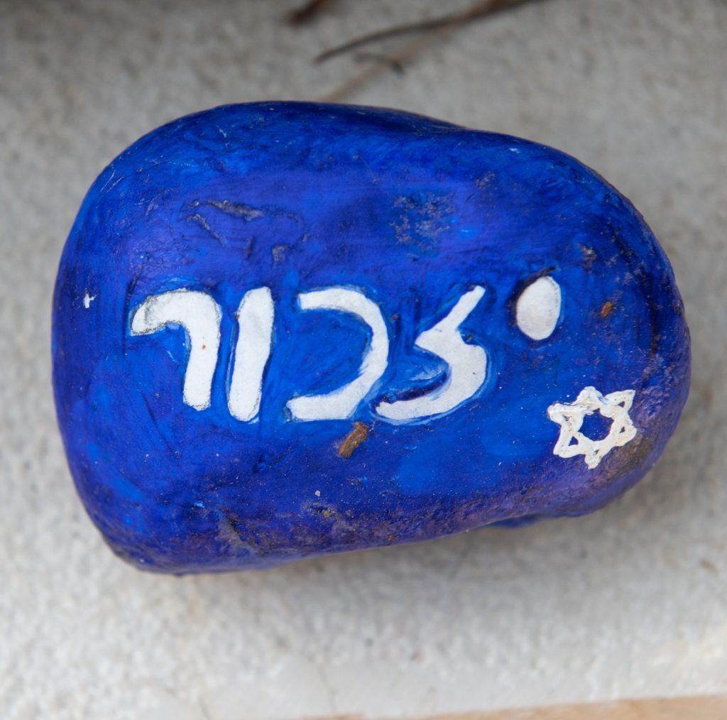 A blue rock with hebrew writing and a star on it