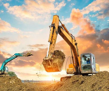 excavator in construction site on sunset sky background
