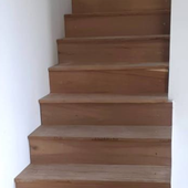Portón de madera y metal negro con panel intercomunicador y puerta de vidrio