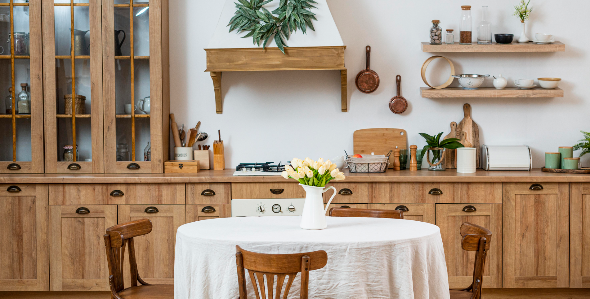 Mano sosteniendo un corazón de metal atravesado por una flecha de metal, contra un cielo nublado y un paisaje urbano.