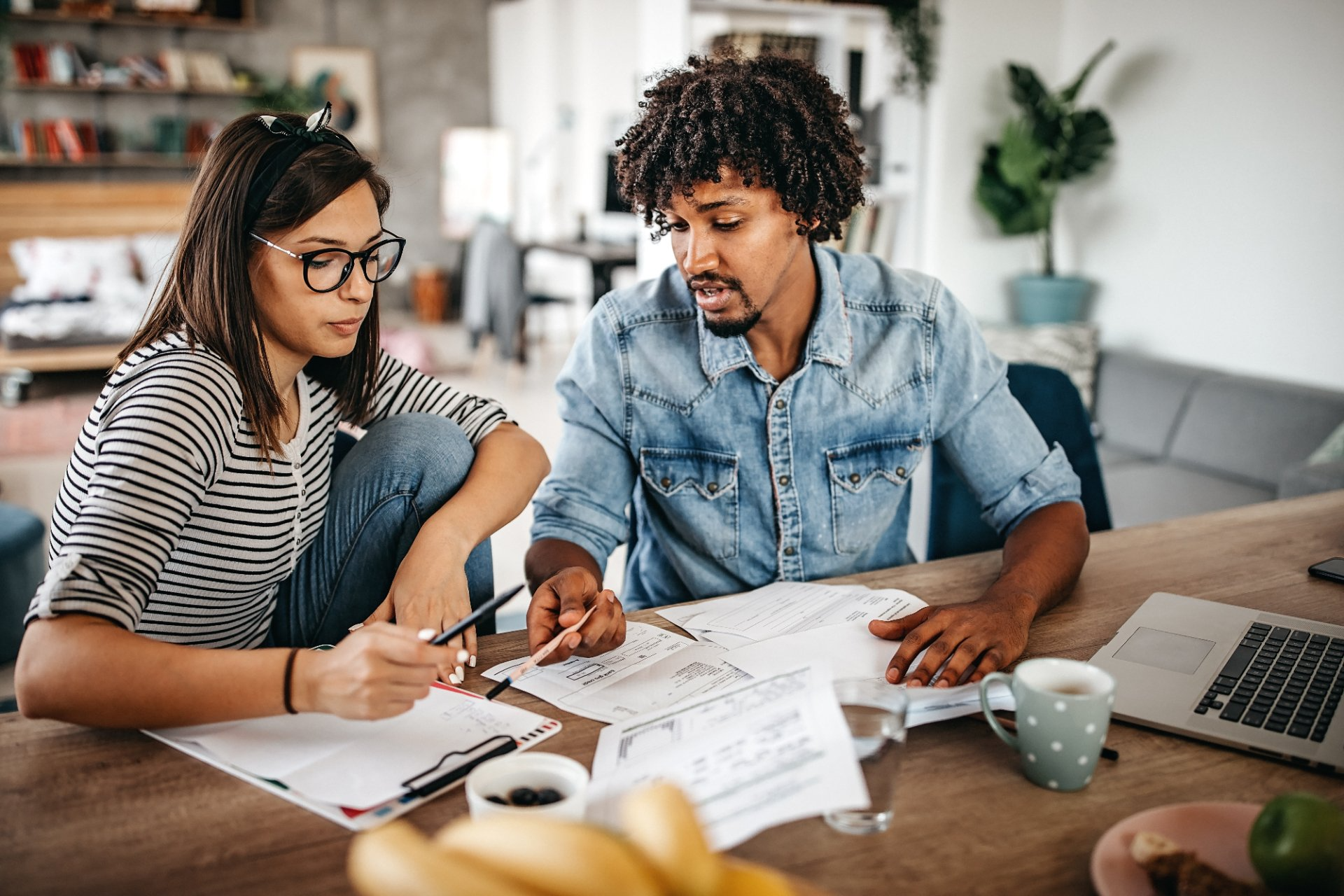 A man and a woman are sitting at a table looking at papers.