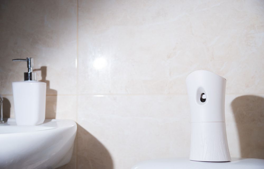 A Bathroom With A Toilet, Sink, And Air Freshener — Aafco Hygiene In Wodonga, VIC