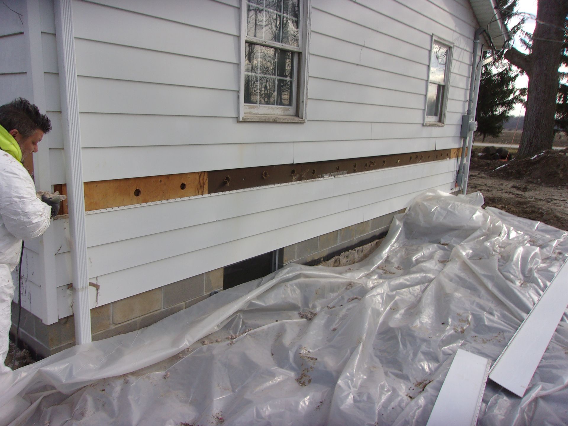 Cellulose blown insulation is applied from the outside of the home and densely packed into the sidewalls of a home