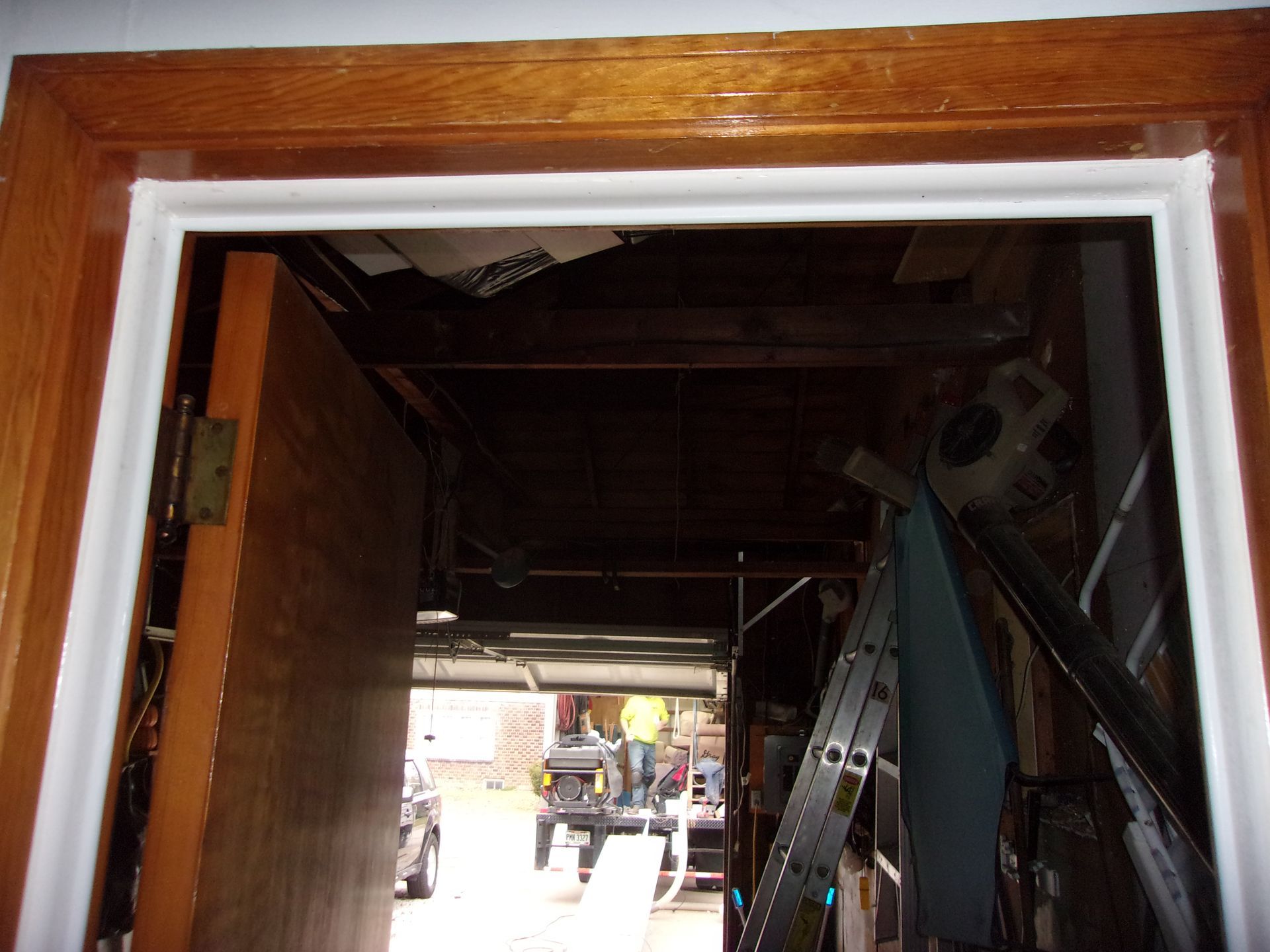 Wooden door frame with white molding around an open doorway leading to a cluttered storage area.