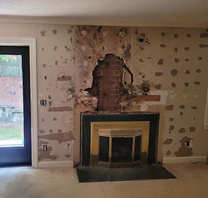 An empty living room with a fireplace and a door.