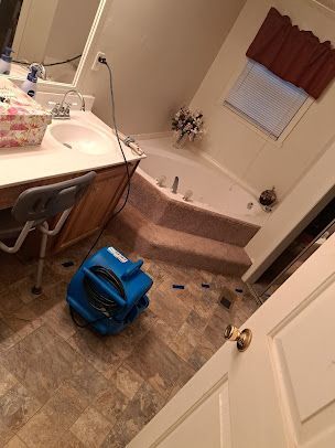 A bathroom with a tub , sink , and mirror.