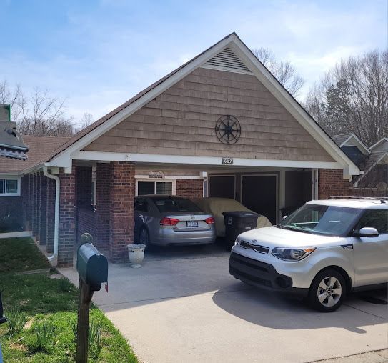 A car is parked in front of a brick house