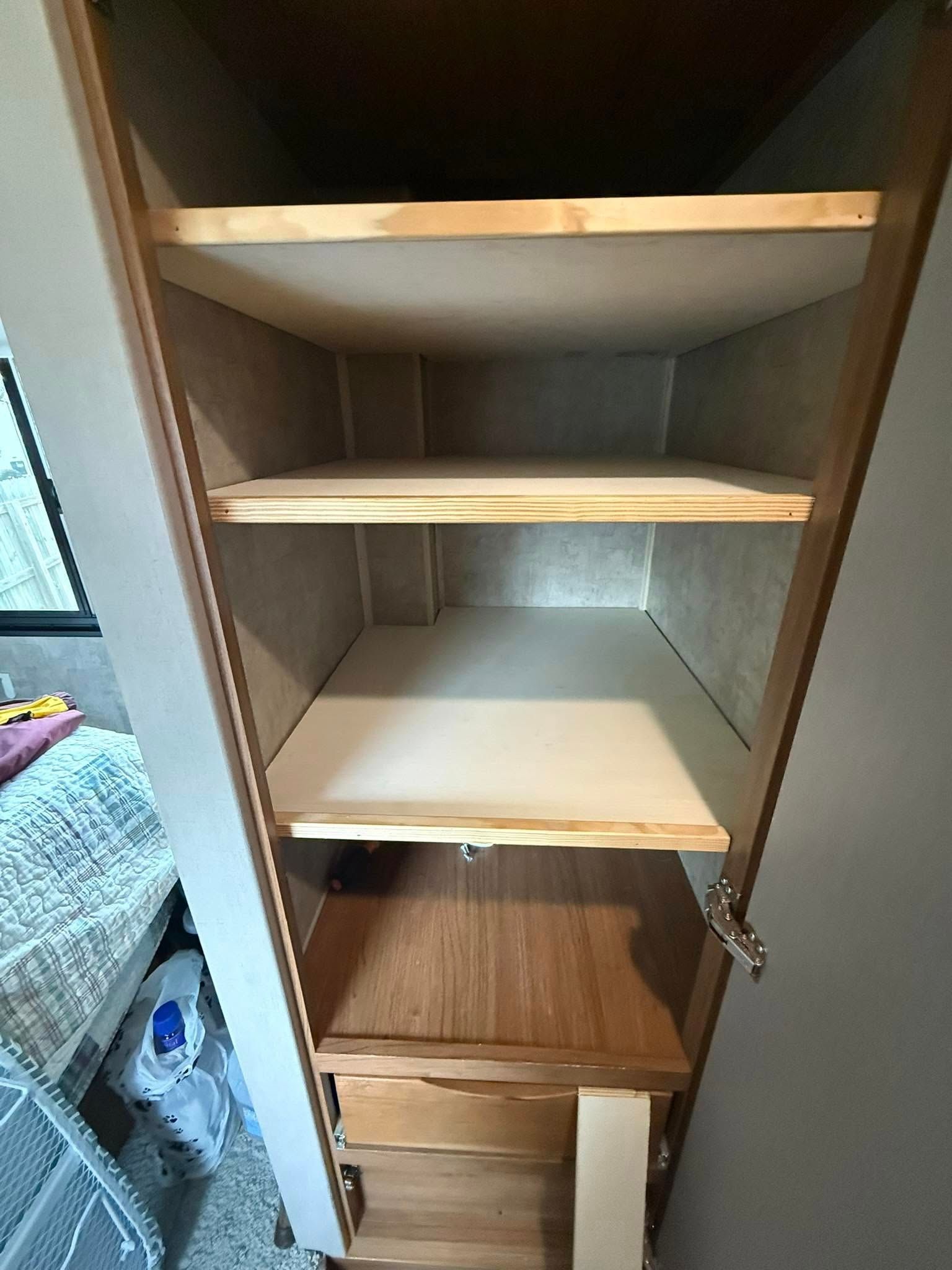 Open tall cabinet with three wooden shelves above a fixed wooden base and two lower storage drawers.