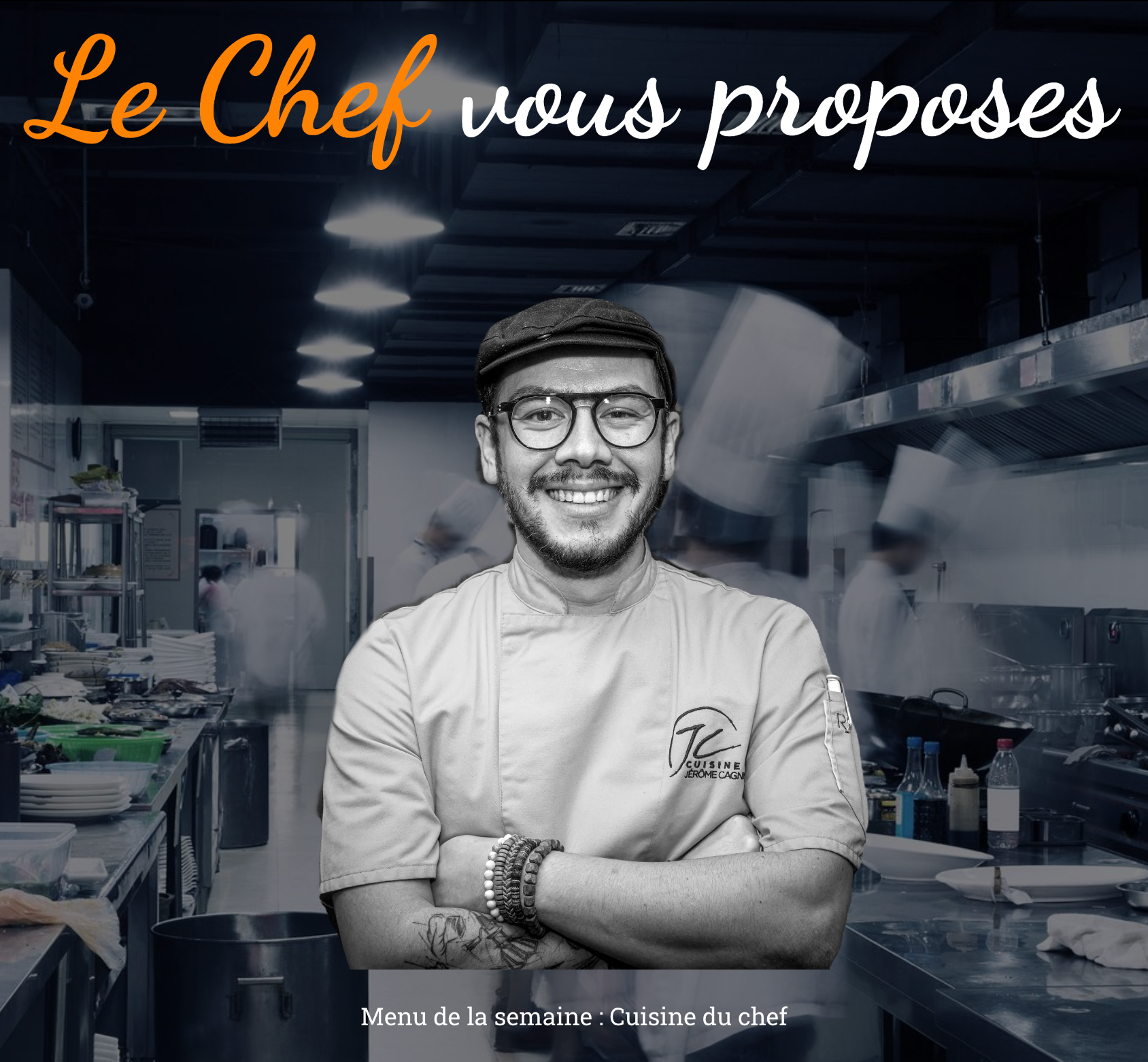 Un homme en uniforme de chef est debout dans une cuisine avec les bras croisés.