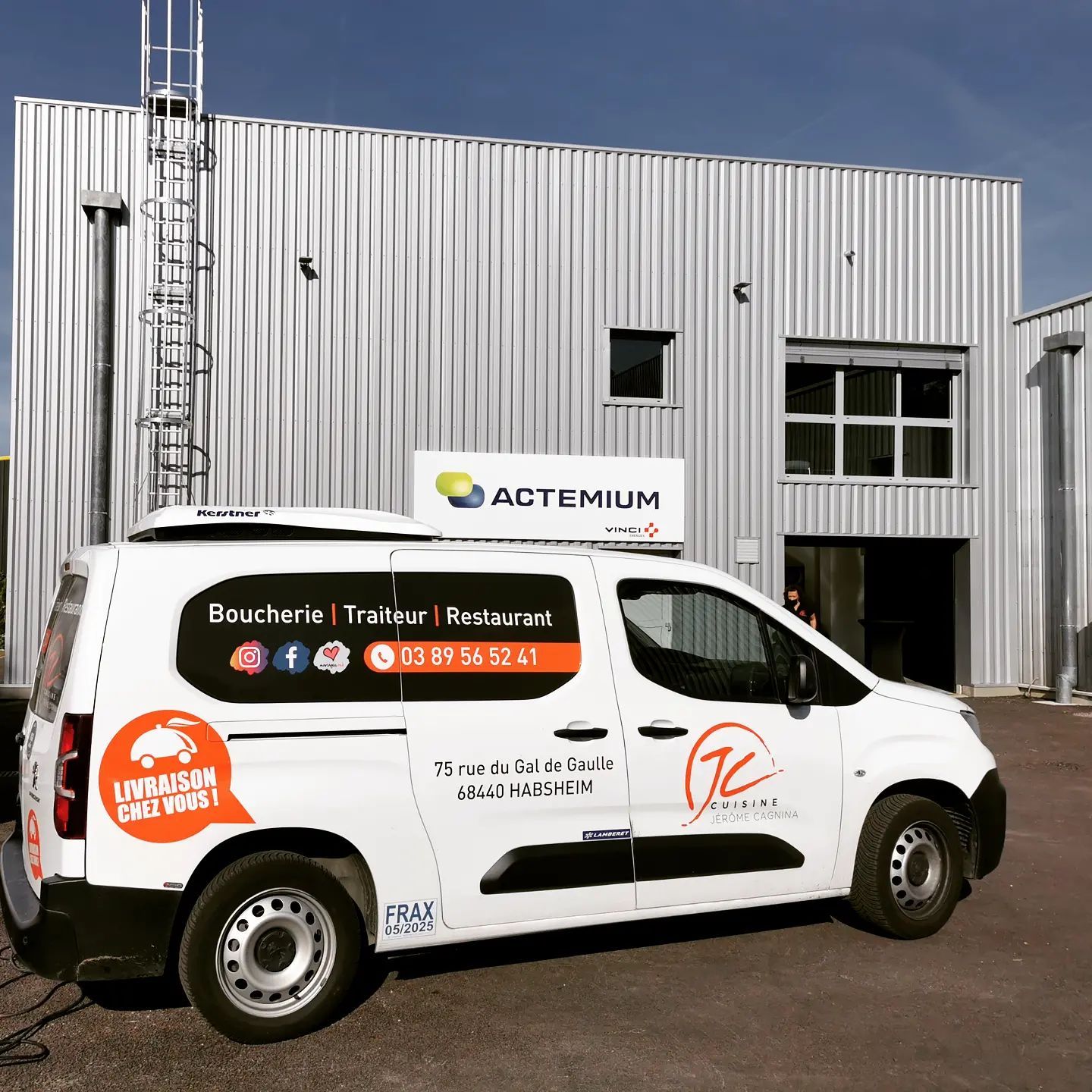 Une camionnette blanche est garée devant un bâtiment.