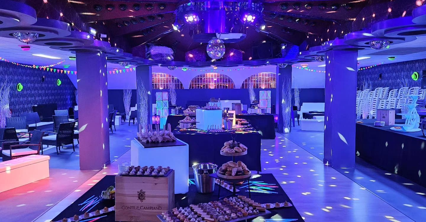 Une grande pièce avec beaucoup de lumières et une boule disco au plafond.