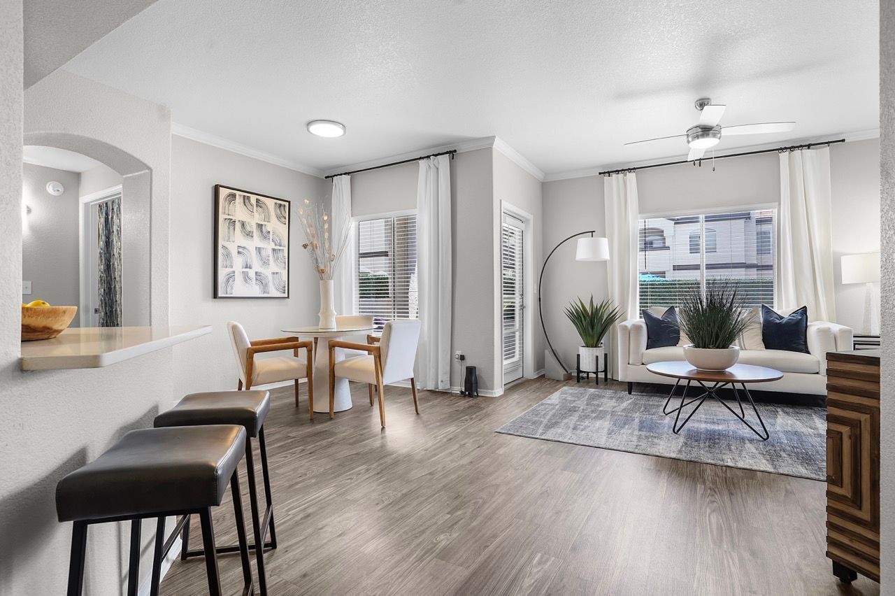 Open-concept living and dining area with sofa, dining set, and large windows at Broadstone Heights in Albuquerque, NM.