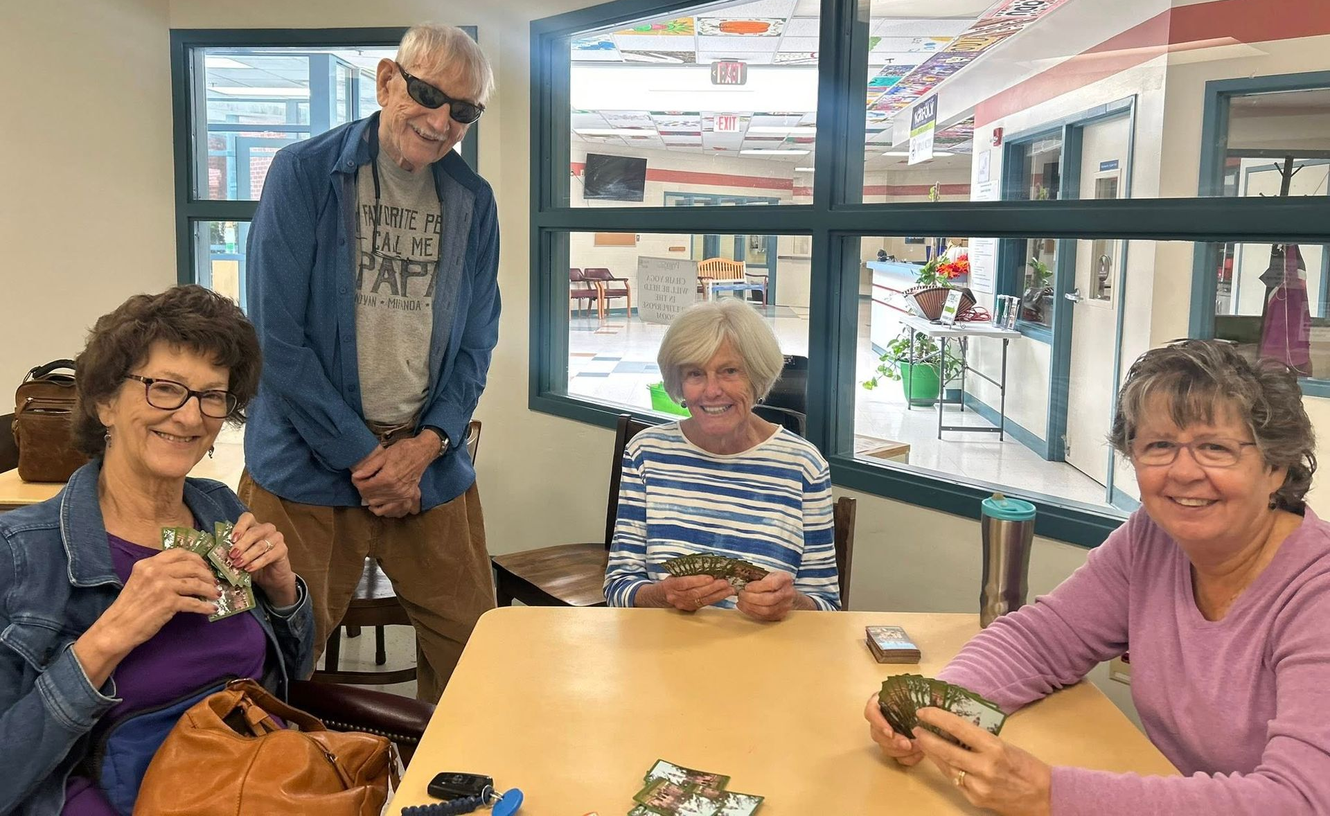 Primeplus members playing cards at a table indoors. 