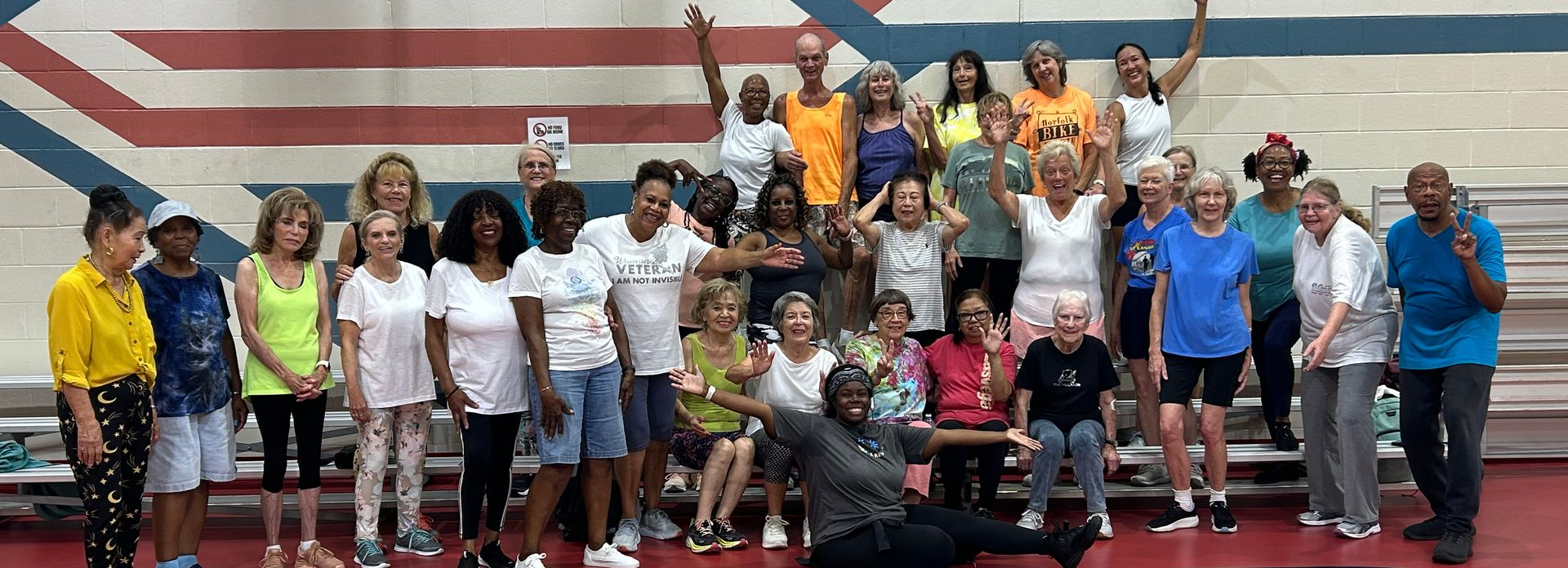 Primeplus members in an indoor setting with arms raised smiling.