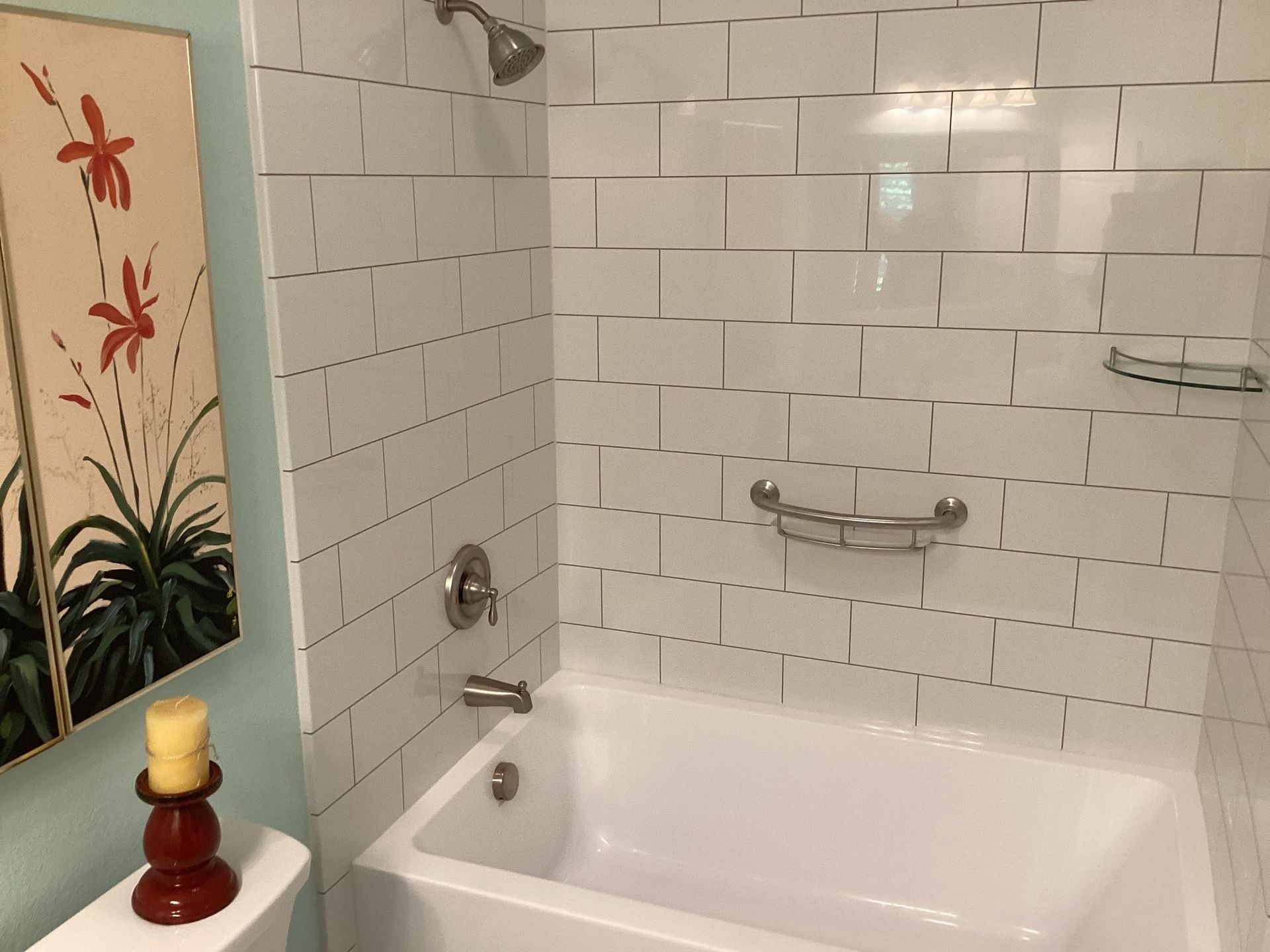 A bathroom with white tiles and a bathtub