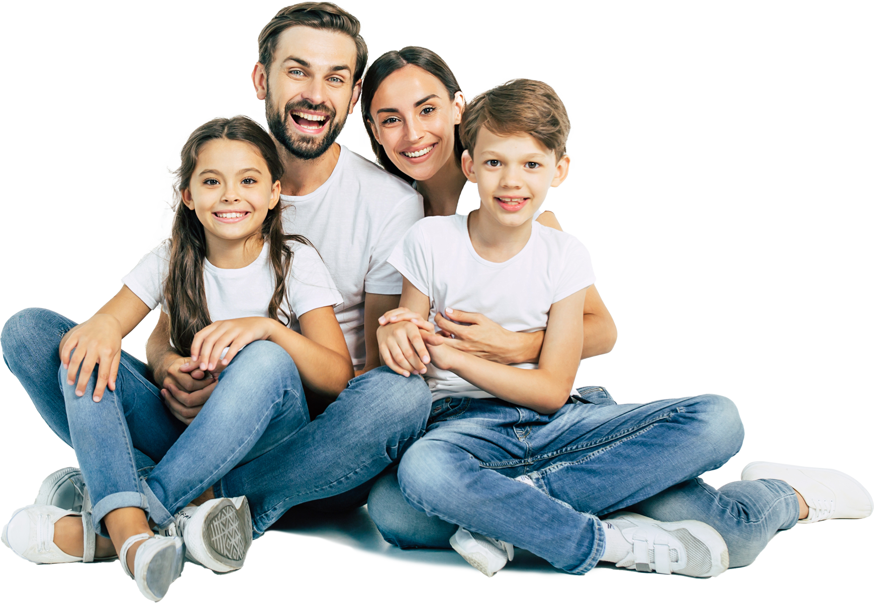 Family of four smiling, sitting close together; two children, parents, casual clothing, white background.