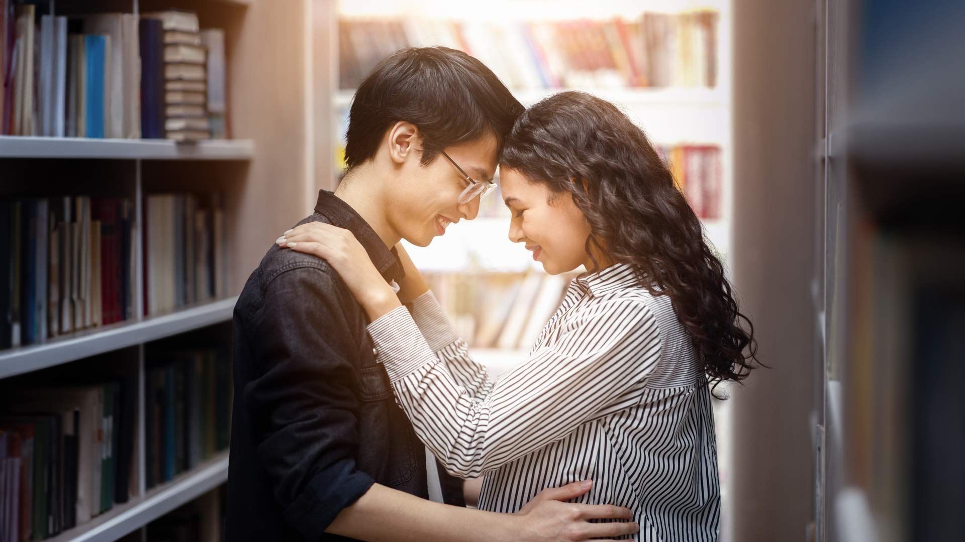 Couple embracing in a library.