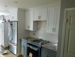 Kitchen with white upper cabinets, gray lower cabinets, and stainless steel appliances.