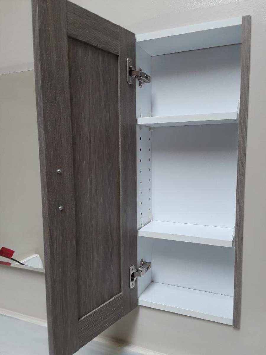 Open gray cabinet with white interior and shelves.
