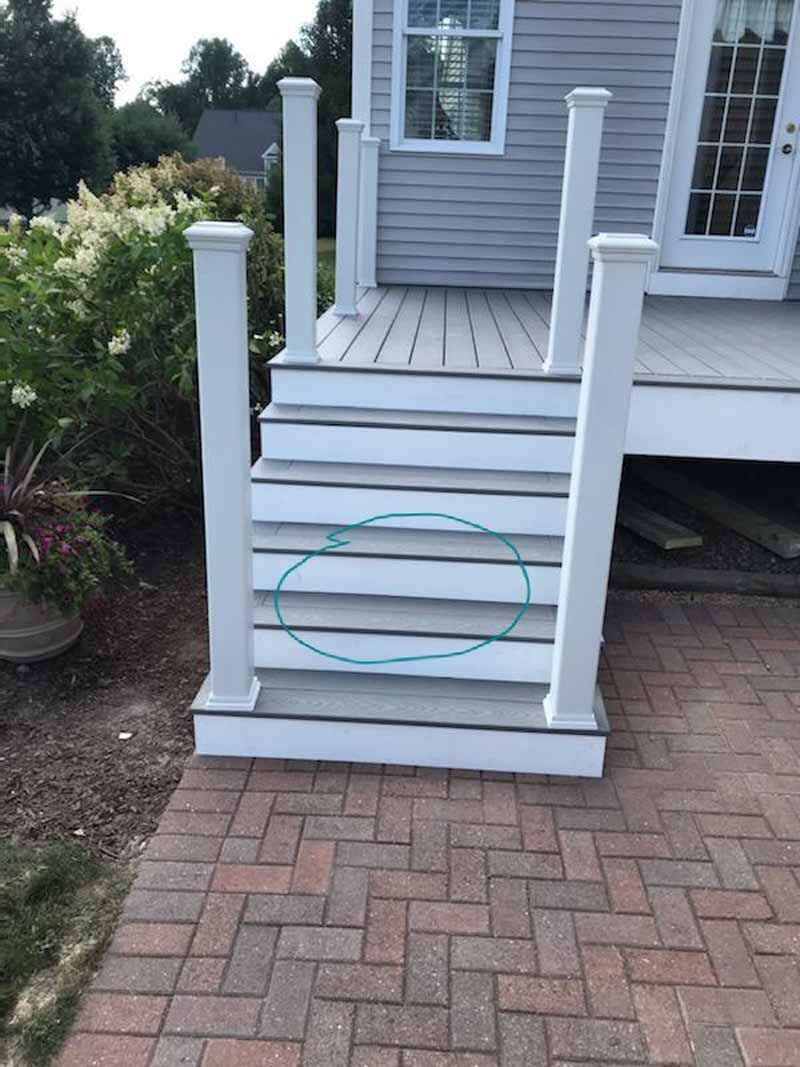 Gray and white outdoor steps leading to a deck, outlined in a blue oval.