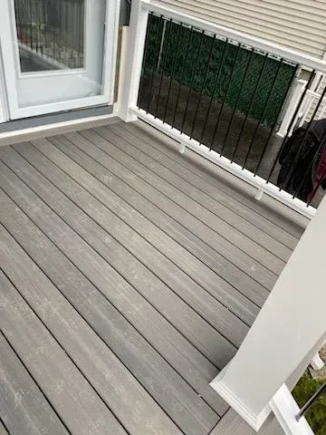 Grey composite deck with white railing and door.