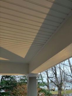 Beige porch ceiling with beam and column. Shadow across the top.
